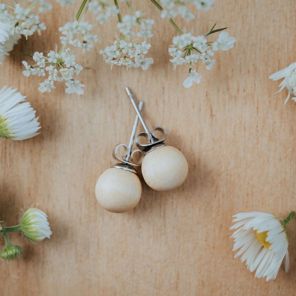 Holzohrstecker Auria Holz Ahorn mit Blumen auf Tisch